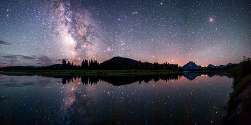 The Milky Way reflected in the Snake River at the famous Oxbow Bend in Grand Teton National Park.